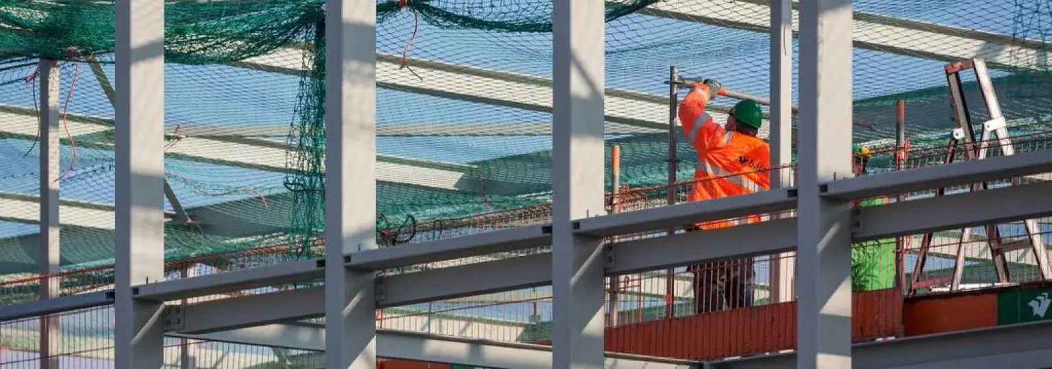 Bouwvakker aan het werk, nieuwe staalconstructie voor betonnen casco