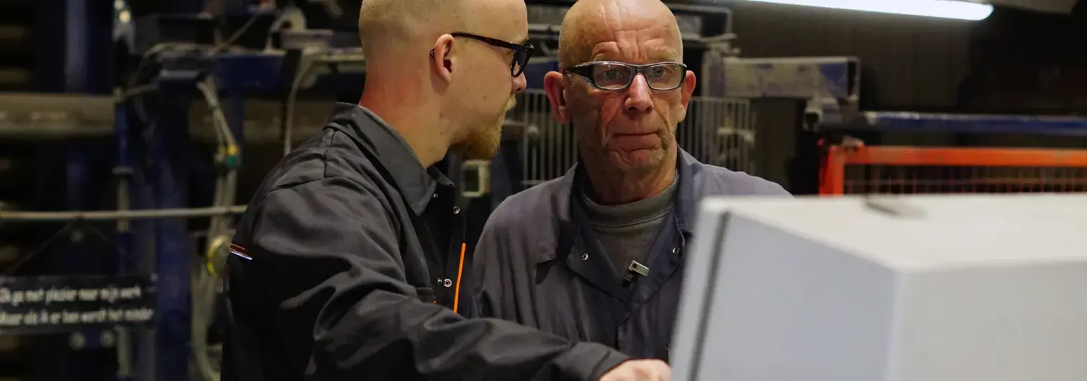 Medewerkers betonfabriek overleggen bij machine 