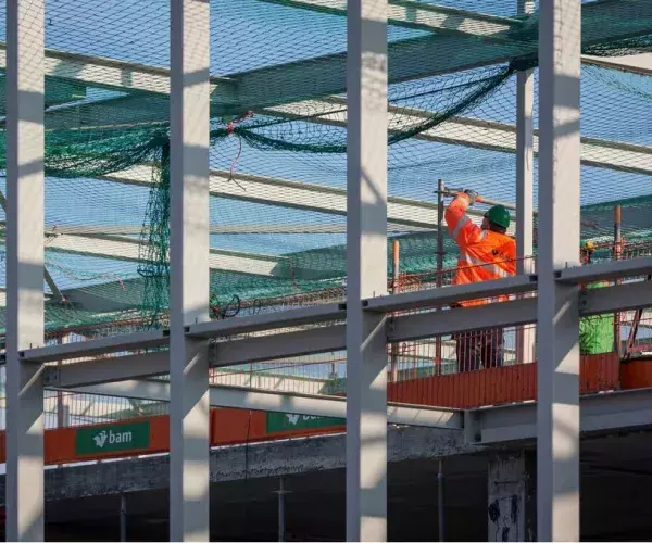 Bouwvakker aan het werk, nieuwe staalconstructie voor betonnen casco