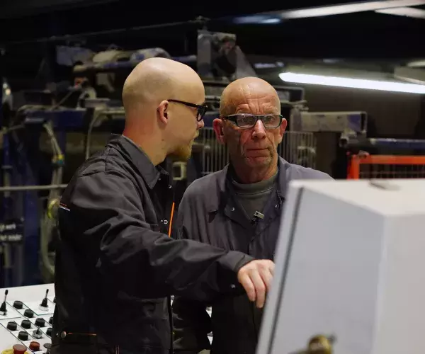 Medewerkers betonfabriek overleggen bij machine 