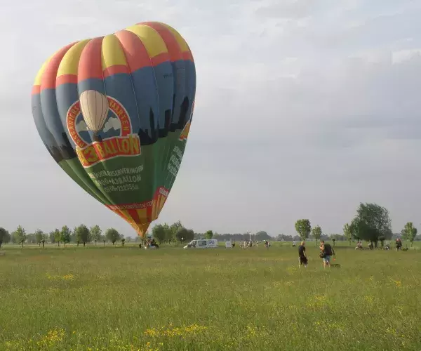 Heteluchtballon midden in weiland op het punt om te vertrekken