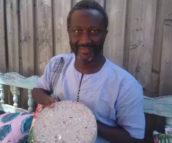 Mohamed laat een proefstuk zien van beton met stro